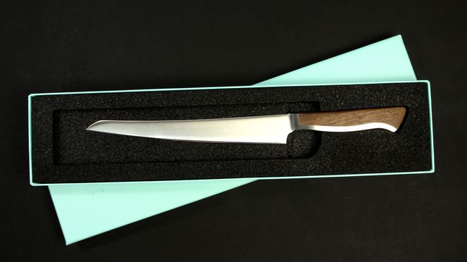 
                    Il coltello per prosciutto Caminada in una scatola di cartone d'alta qualità