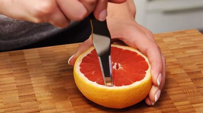 
                    Le couteau à pamplemousse coupant un grapefruit